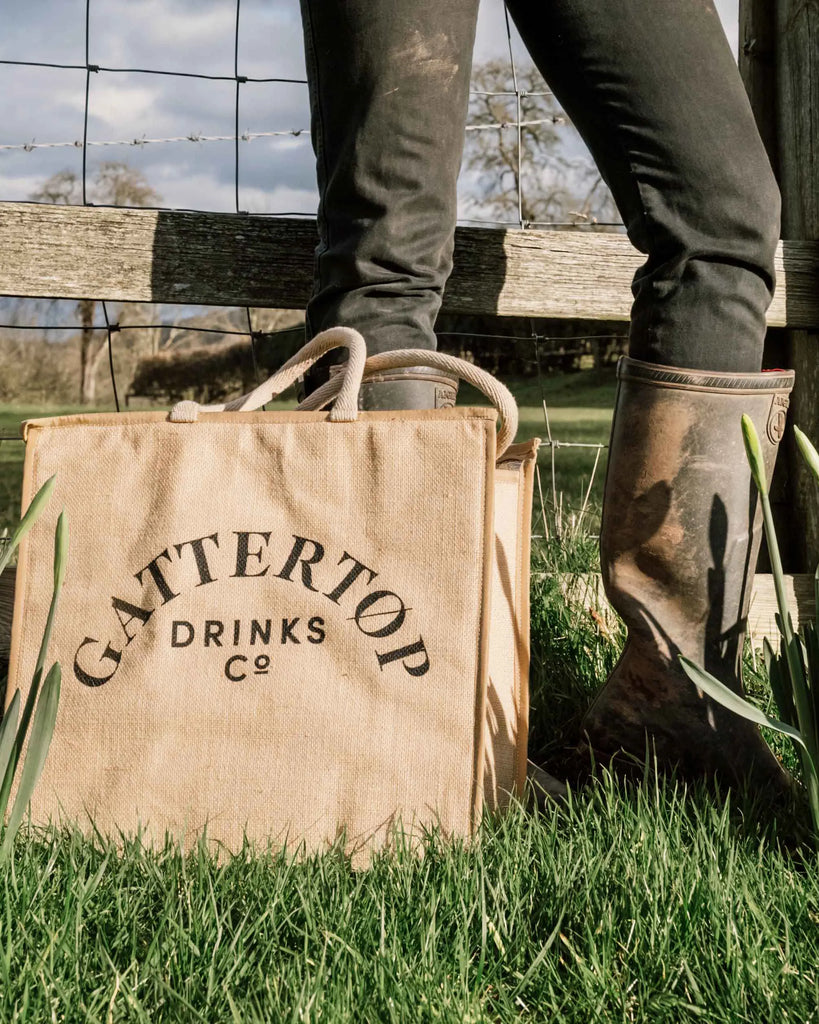 Spring Equinox, Gattertop branded picnic bag next to budding flowers, spring inspired cocktail